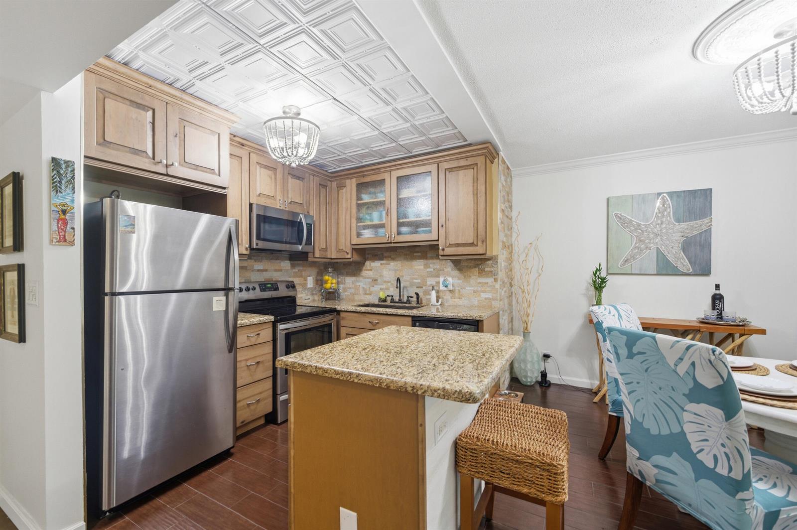 A kitchen features wood cabinets, granite countertops, stainless steel appliances, and a decorative ceiling — 101 E Mcnab Road # 102, Pompano Beach FL 33060, POMPANO BEACH, FL