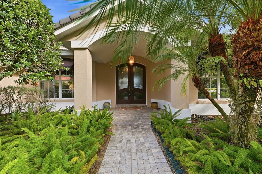 A tiled entryway features a wooden bookshelf, a hanging light fixture, and double glass doors — 108 LAKE REGION BOULEVARD N, WINTER HAVEN, FL