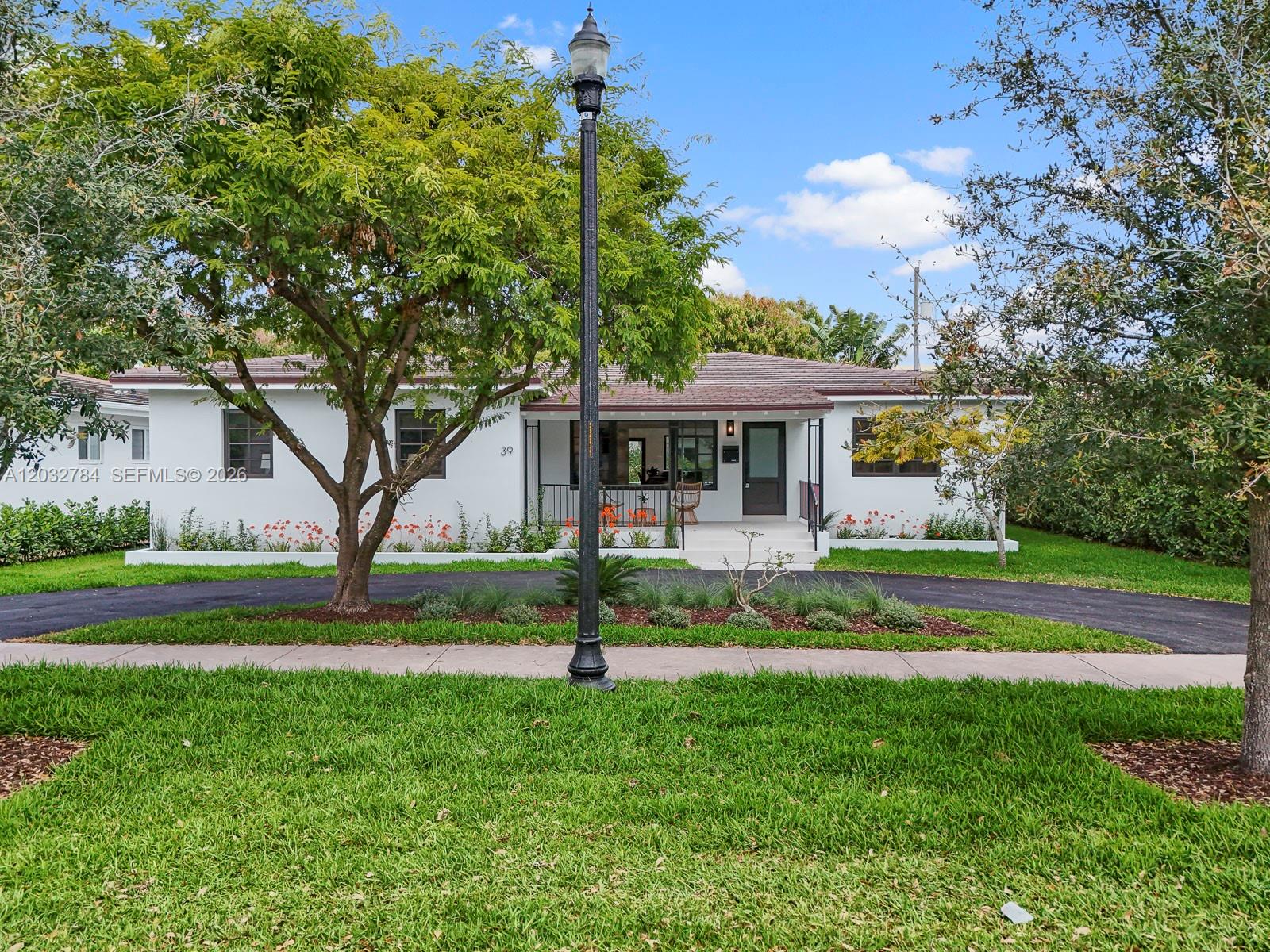 A white single-story house with a dark roof, front porch, and curved driveway — 39 Palermo Ave, Coral Gables FL 33134, CORAL GABLES, FL