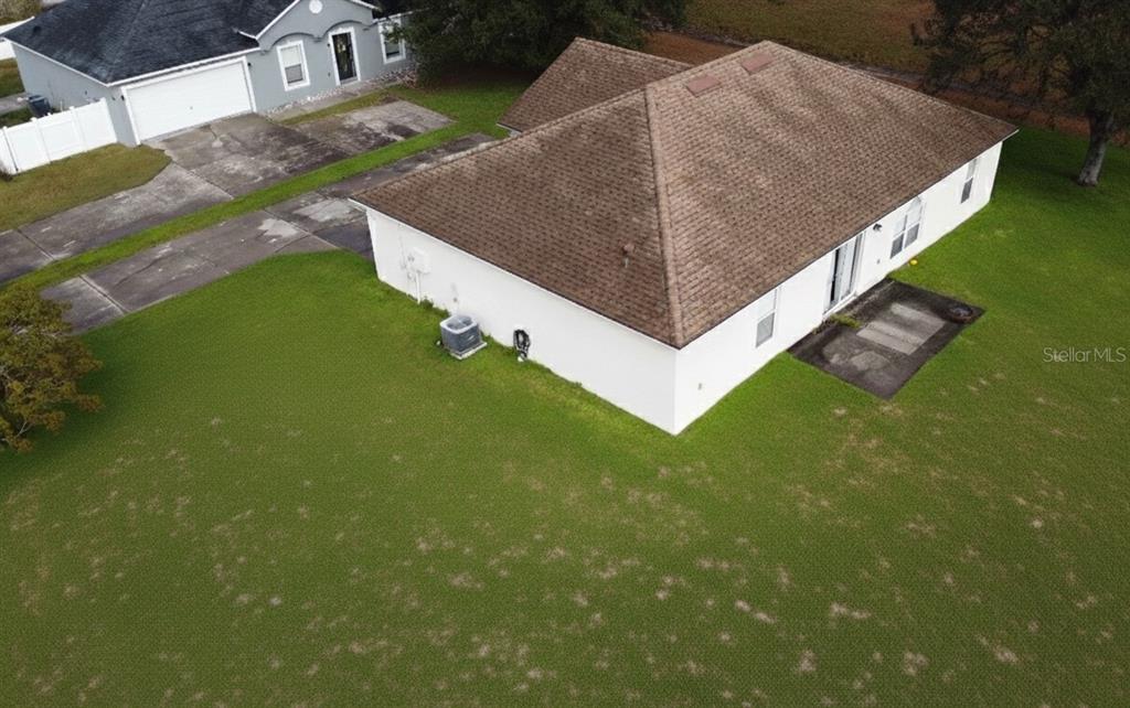 An aerial view shows the back of a house with a brown roof and lawn — 1346 DUNBARTON COURT, KISSIMMEE, FL