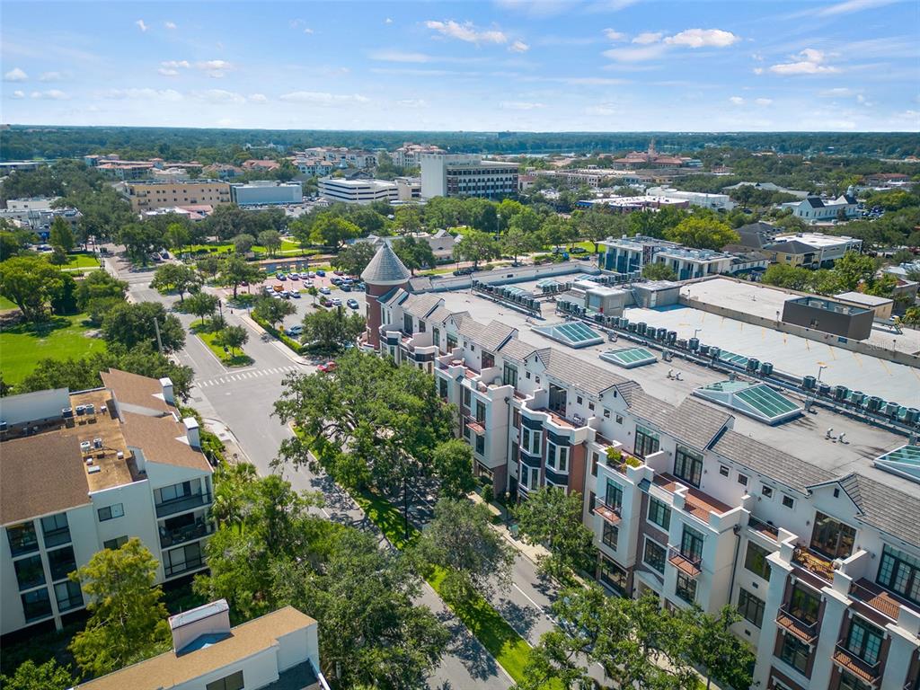 An aerial view shows a multi-story residential building with a turret next to a street — 101 S NEW YORK AVENUE UNIT 311, WINTER PARK, FL