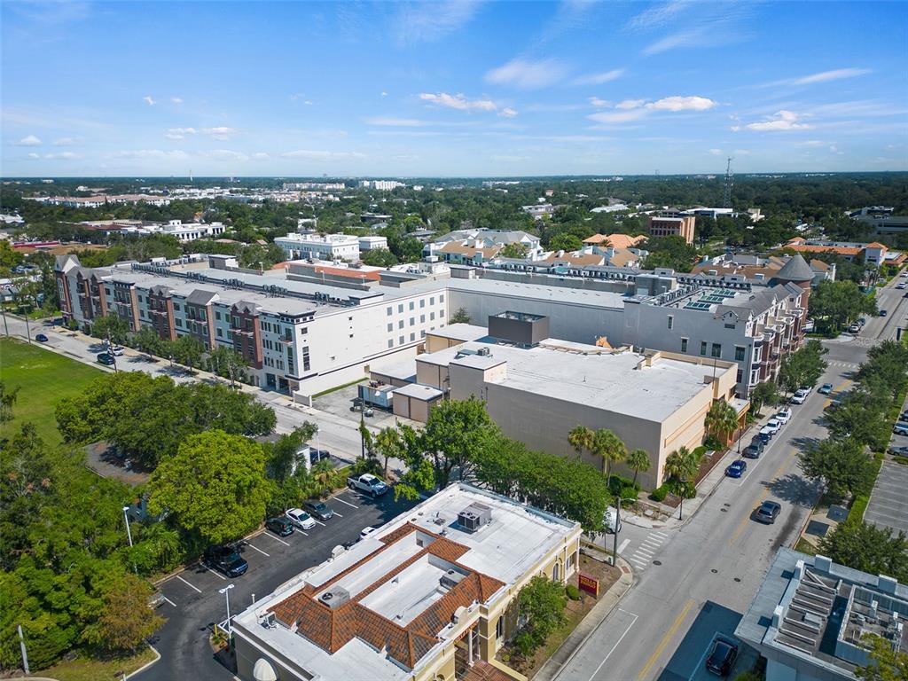 An aerial view shows a multi-story apartment complex and a commercial building with parking lots — 101 S NEW YORK AVENUE UNIT 311, WINTER PARK, FL