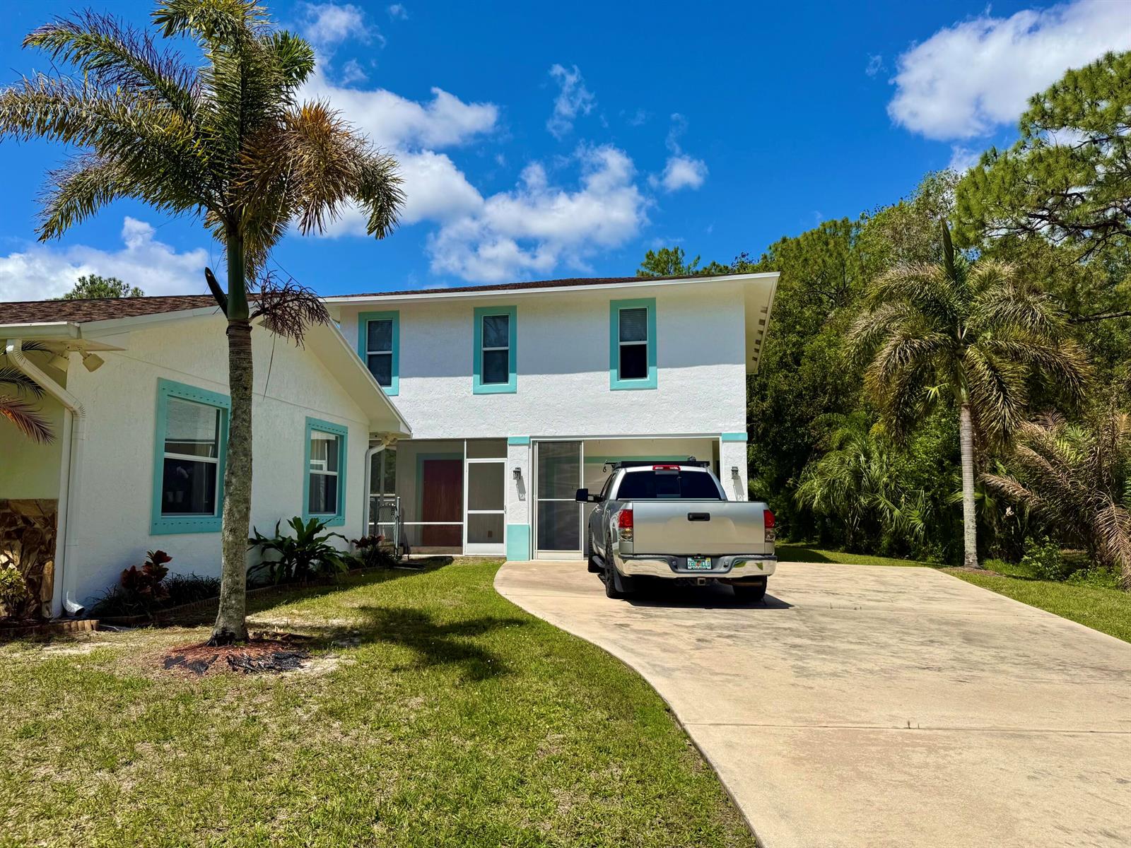 A two-story white house with teal trim and a pickup truck parked in the driveway — 16283 Alexander Run, Jupiter FL 33478, JUPITER, FL