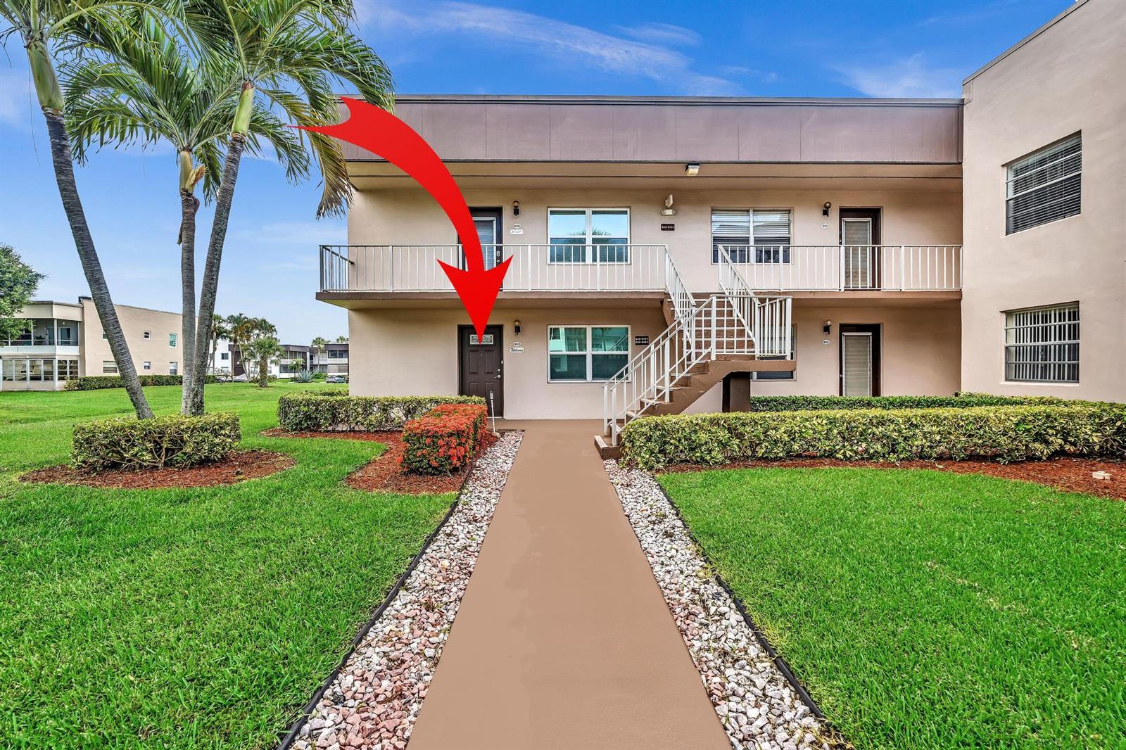 A two-story apartment building exterior features a ground-floor entrance marked by a red arrow — 625 Normandy N # 625, Delray Beach FL 33484, DELRAY BEACH, FL
