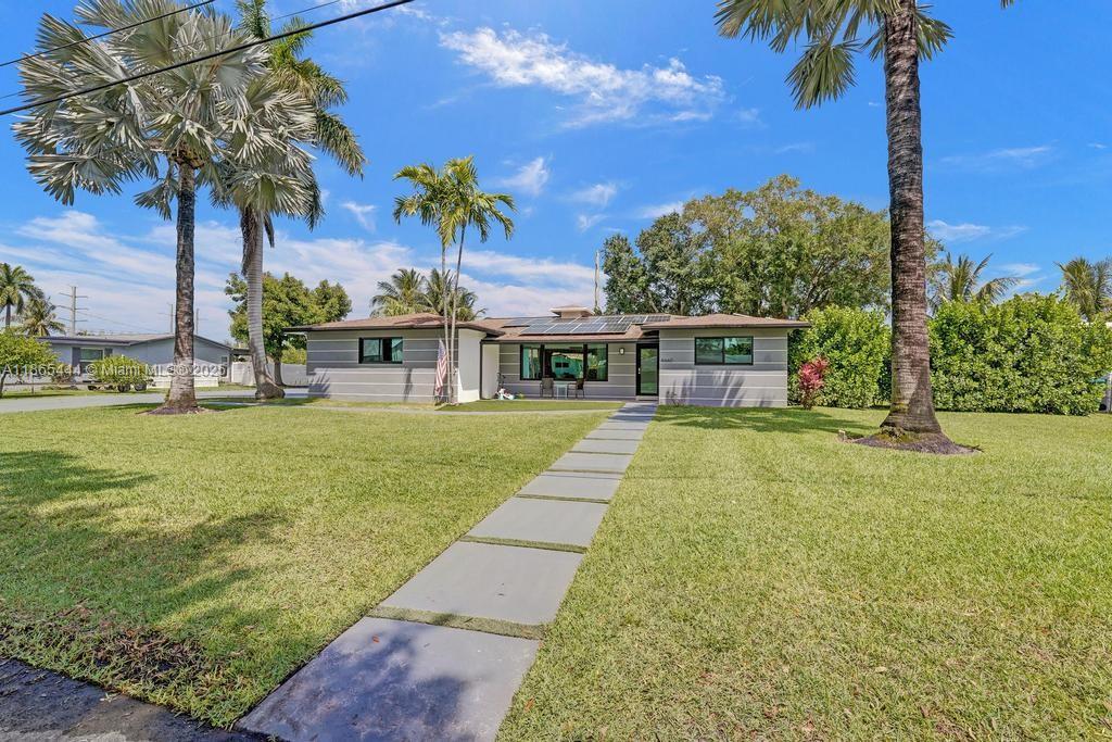 A single-story house with a gray exterior, solar panels, and a stone walkway in Florida — 4660 SW 37th Ave, Dania Beach FL 33312, DANIA BEACH, FL