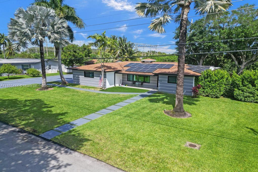 A single-story house with a brown shingled roof, solar panels, and a large front lawn — 4660 SW 37th Ave, Dania Beach FL 33312, DANIA BEACH, FL