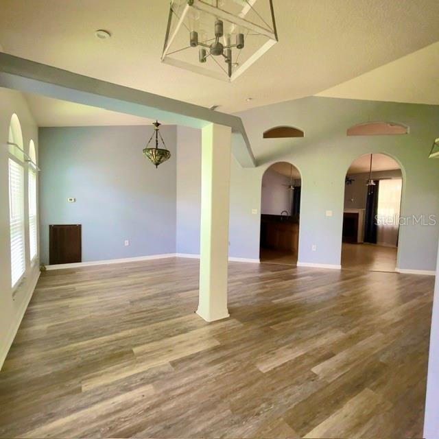 An open-concept living area features light blue walls, wood-look flooring, and two arched doorways — 259 NORWALK CIRCLE, EAGLE LAKE, FL