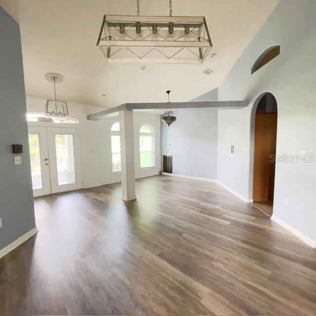 An open living area features wood-look flooring, light blue walls, and three hanging light fixtures — 259 NORWALK CIRCLE, EAGLE LAKE, FL