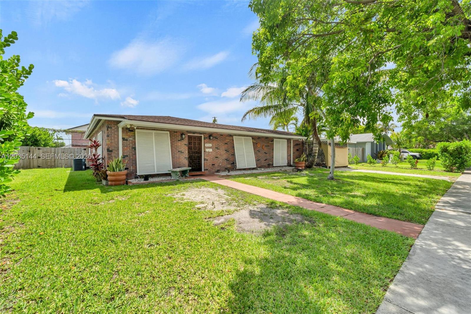 A single-story brick house with white shutters sits on a grassy lot with trees — 9982 SW 196th St, Cutler Bay FL 33157, CUTLER BAY, FL