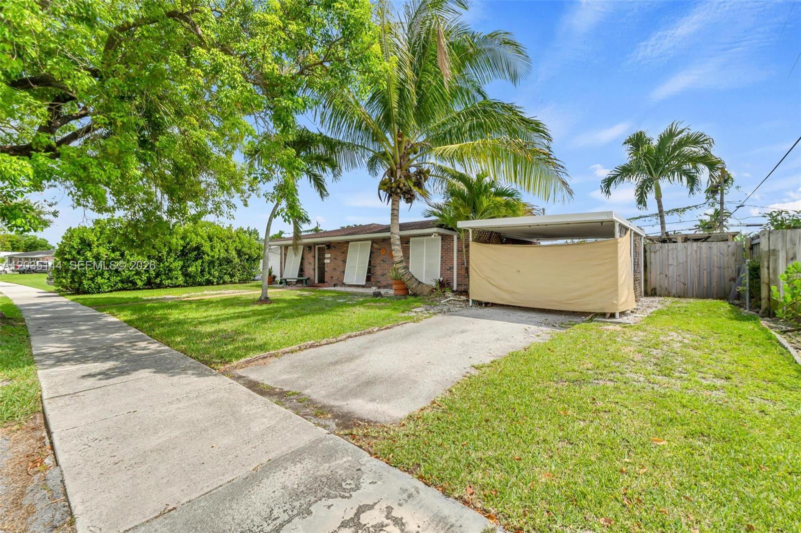 A single-story brick house features a palm tree, a covered carport, and a front lawn — 9982 SW 196th St, Cutler Bay FL 33157, CUTLER BAY, FL