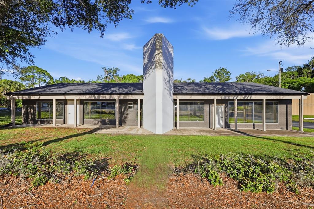A single-story commercial building with a central white chimney and a covered front porch — 346 N VOLUSIA AVENUE, ORANGE CITY, FL