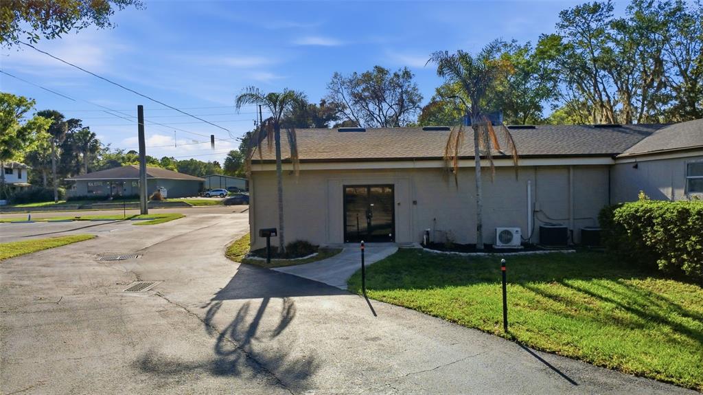 The exterior of a single-story commercial building features a paved driveway and two palm trees — 346 N VOLUSIA AVENUE, ORANGE CITY, FL
