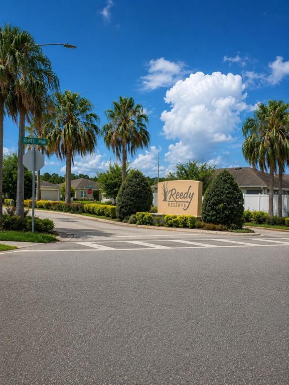 The entrance to the Reedy Reserve community features a monument sign, palm trees, and landscaping — 4592 BIG ISLAND DRIVE, KISSIMMEE, FL