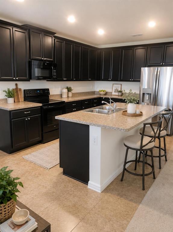 A kitchen features black cabinets, a beige speckled island, and stainless steel appliances — 4592 BIG ISLAND DRIVE, KISSIMMEE, FL