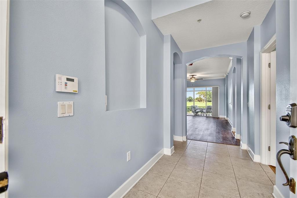 A light blue entryway leads to a hallway with tile flooring and a view outside — 200 RIVERFRONT DRIVE UNIT D103, PALM COAST, FL