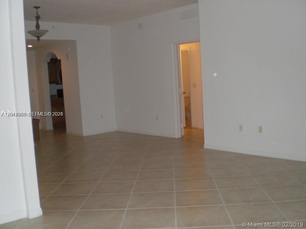 An interior view shows a room with beige tile flooring and white walls — 3590 CORAL WAY # 902, Miami FL 33145, MIAMI, FL