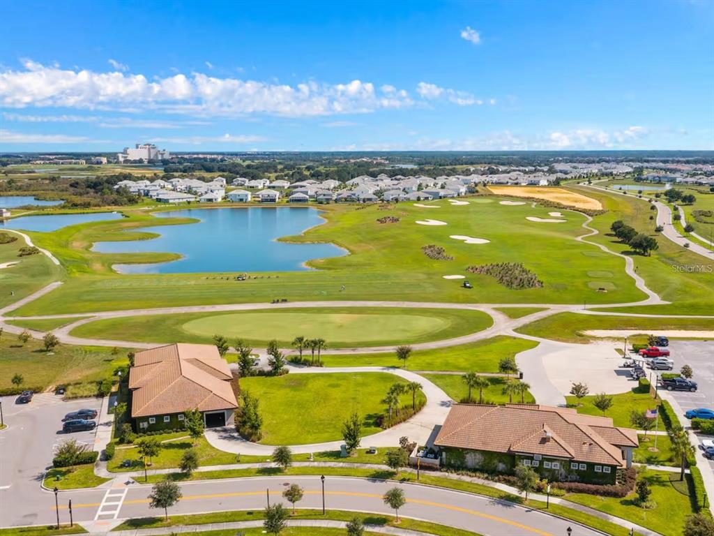 An aerial view shows a golf course, a lake, and two buildings with parking lots — 1043 SPLASH SHOT PLACE UNIT 2002, DAVENPORT, FL