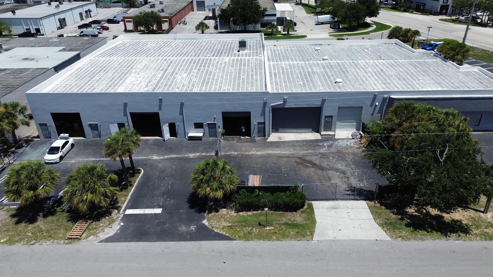 An aerial view shows a gray industrial building with multiple bay doors and a parking lot — 1300 Old Dixie Highway # 108, Lake Park FL 33403, LAKE PARK, FL
