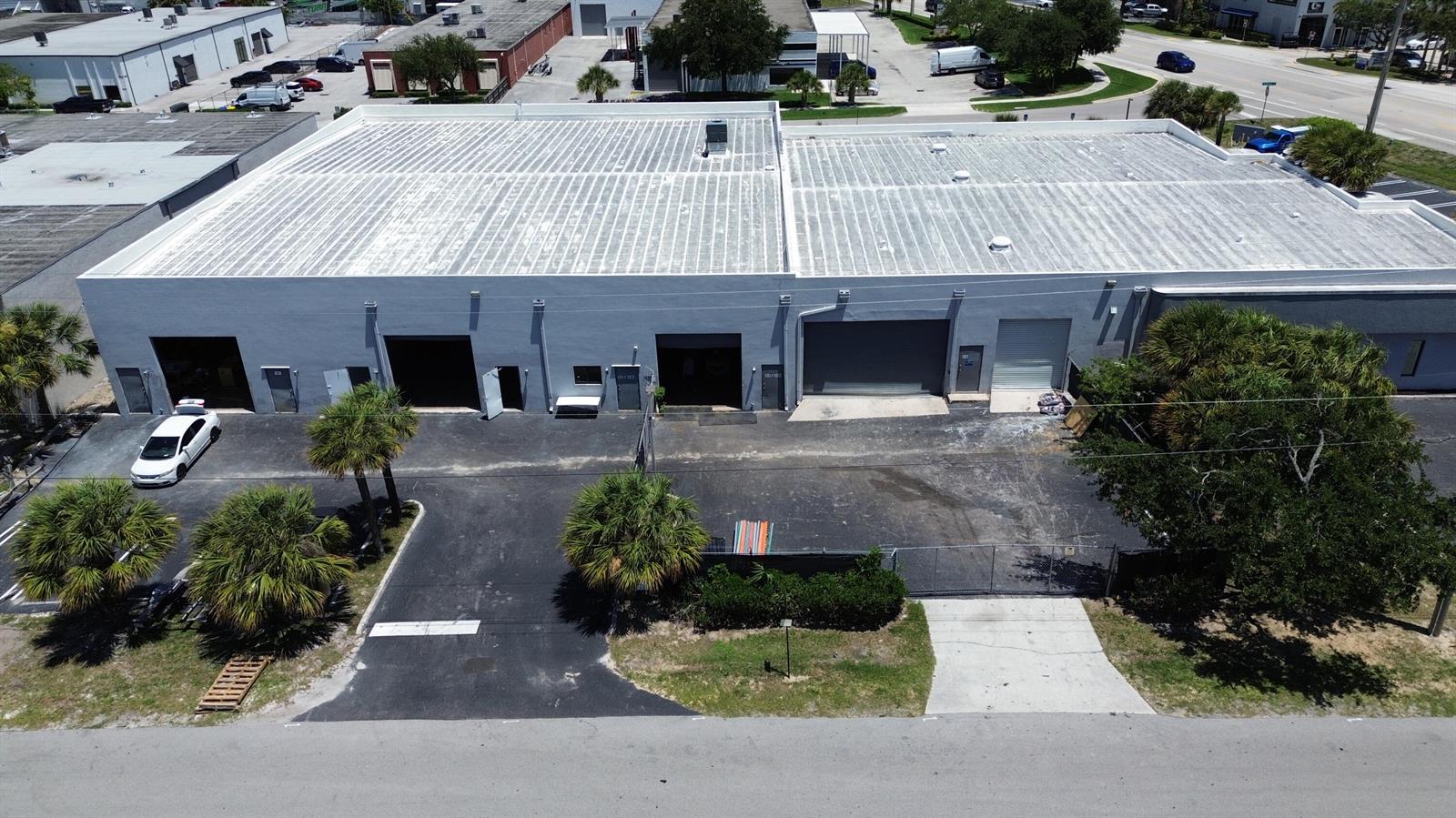 An aerial view shows a gray industrial warehouse building with multiple loading bays and parking — 1300 Old Dixie Highway # 108, Lake Park FL 33403, LAKE PARK, FL