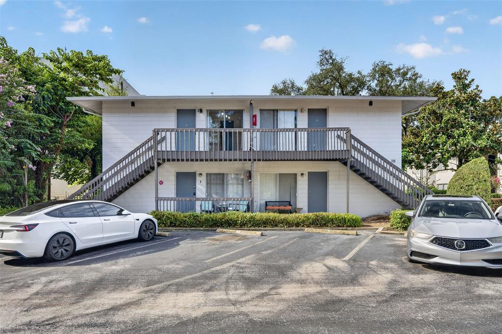 A two-story apartment building with exterior staircases, a balcony, and a parking lot in front — 118 W AMERICA STREET UNIT 2, ORLANDO, FL