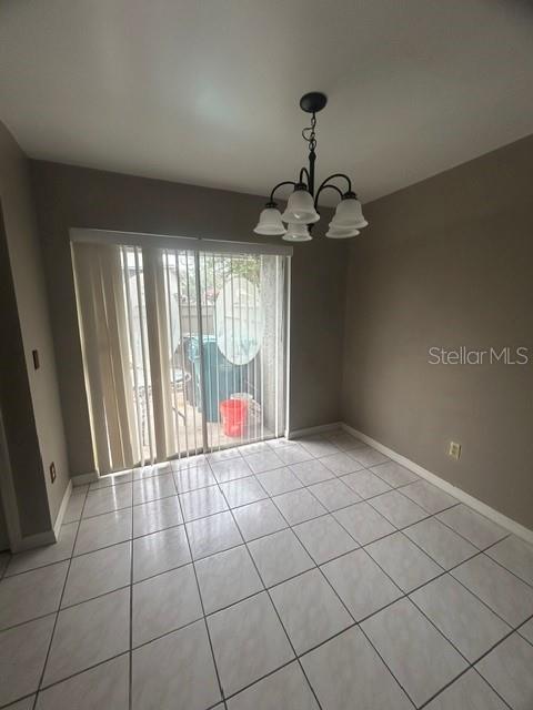 A dining area features tile flooring, a chandelier, and a sliding glass door to a patio — 4403 PRAIRIE COURT UNIT B, ORLANDO, FL
