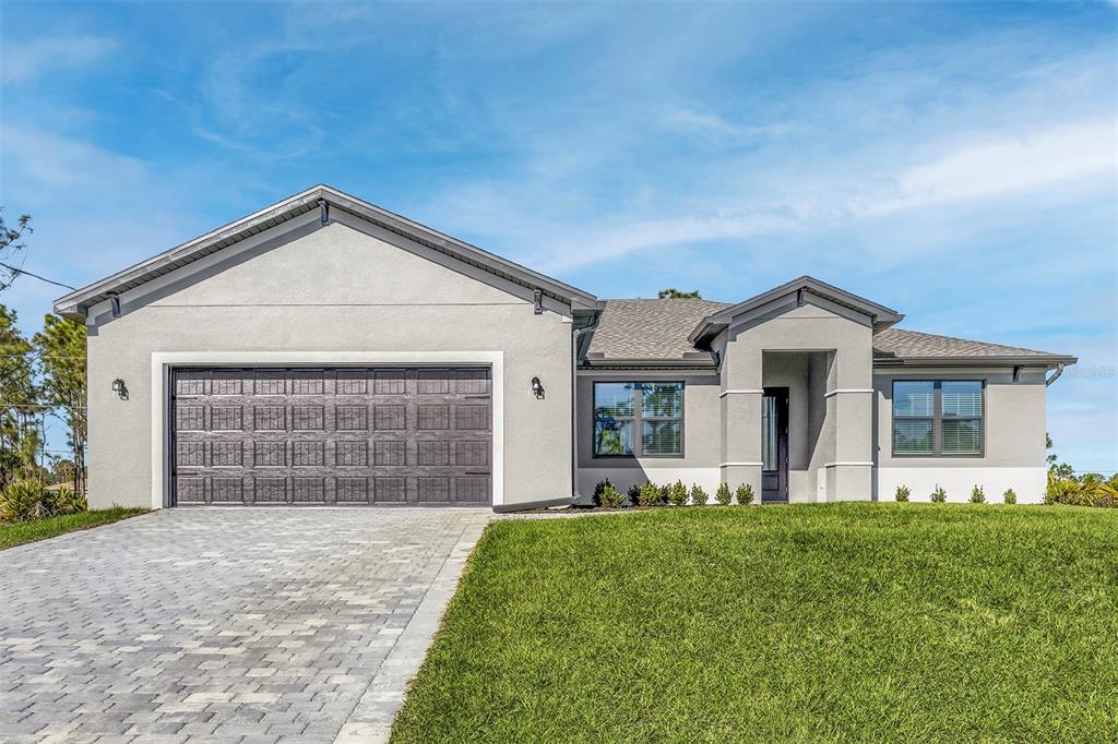 A single-story house with a gray stucco exterior, a two-car garage, and a paved driveway — 5227 DAYTON LANE, PORT CHARLOTTE, FL