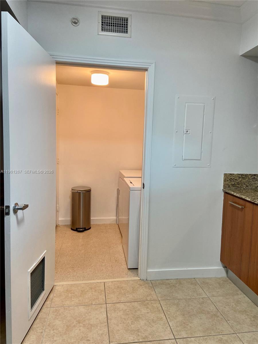 A laundry closet with a washer and dryer is visible through an open doorway — 9055 SW 73rd Ct # 1709, Miami FL 33156, MIAMI, FL