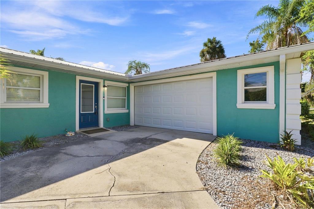A teal house features a white garage door, a blue front door, and a concrete driveway — 1791 NW 21ST COURT, CRYSTAL RIVER, FL