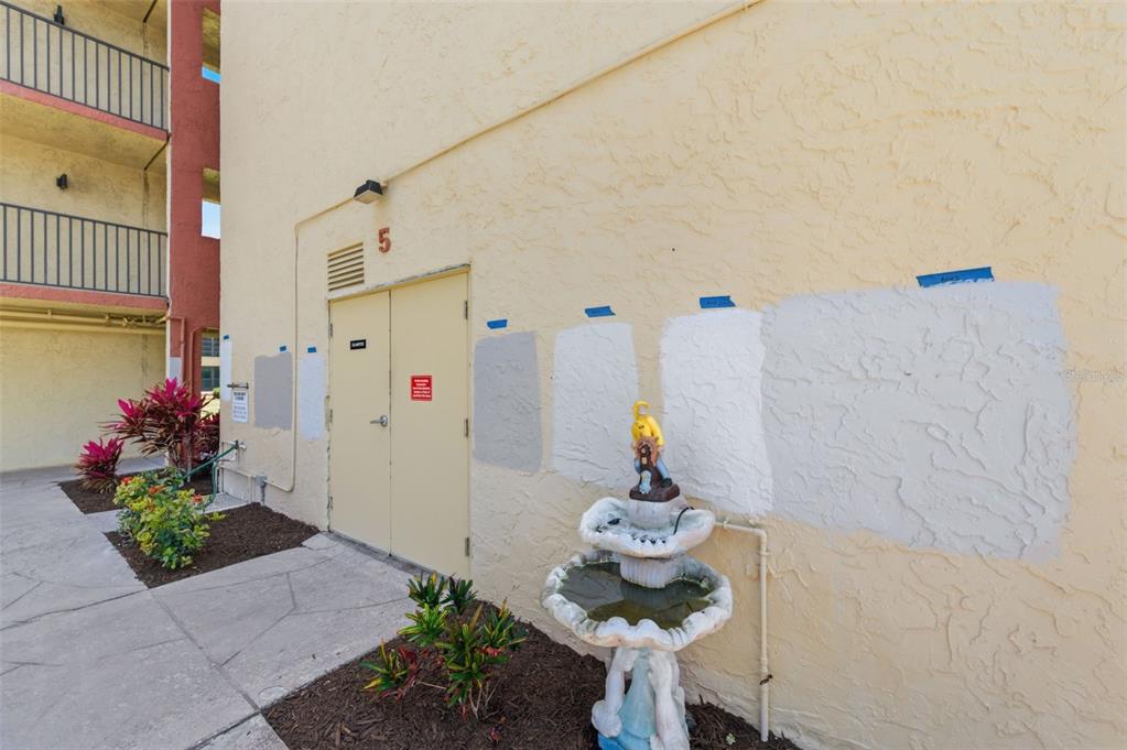 Exterior view of a building wall featuring several paint color samples and a small fountain — 19701 GULF BOULEVARD UNIT 417, INDIAN SHORES, FL