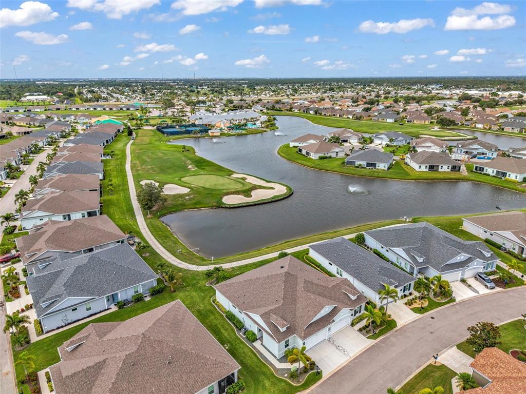 An aerial view shows residential houses surrounding a golf course green and a large pond — 24343 WESTGATE BOULEVARD, PUNTA GORDA, FL