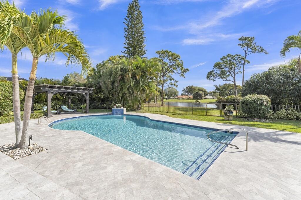 A backyard swimming pool with a pergola, patio, and a view of a pond — 355 Oakview Drive, Delray Beach FL 33445, DELRAY BEACH, FL