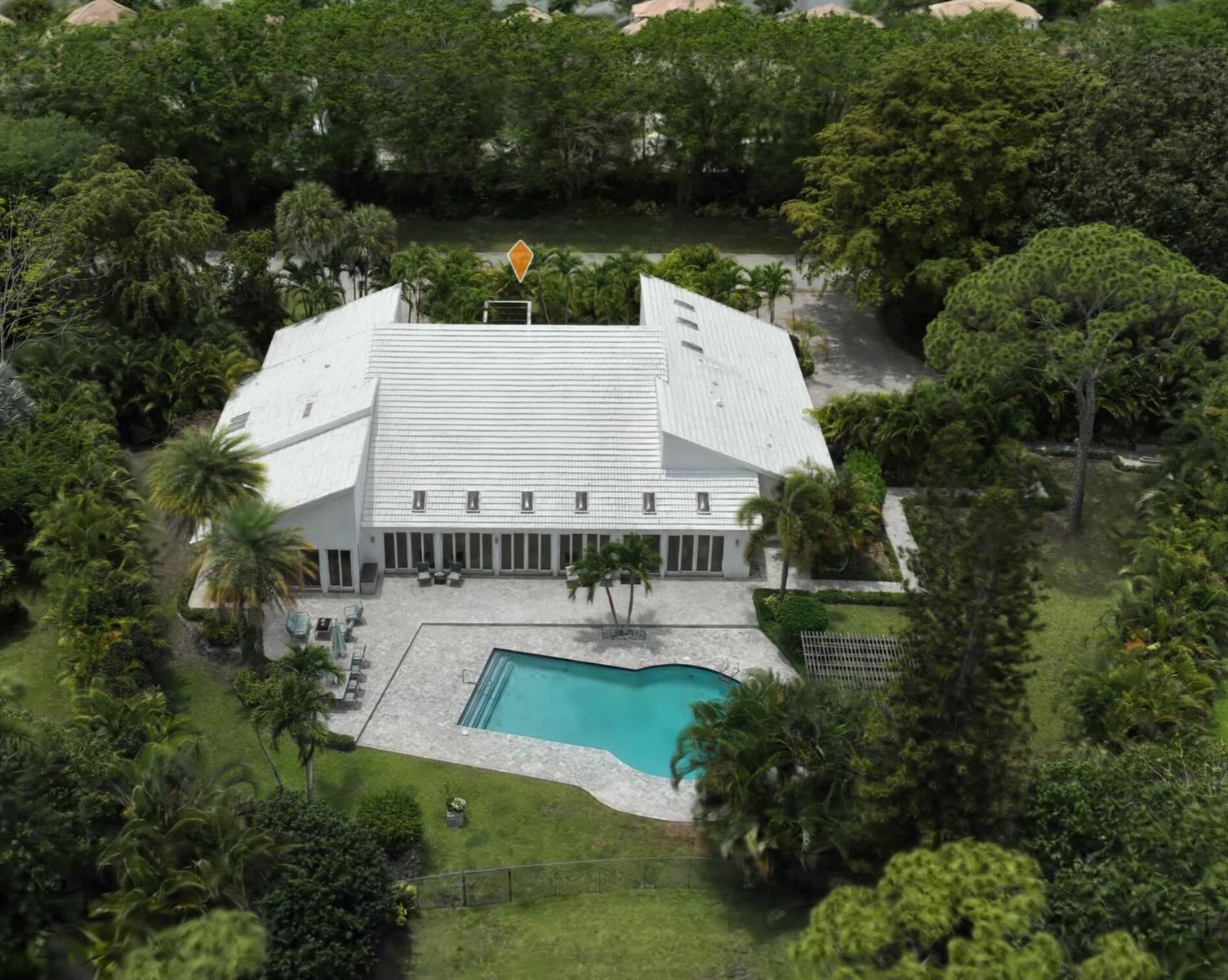 An aerial view shows a white house with a pool, patio, and surrounding lush trees — 355 Oakview Drive, Delray Beach FL 33445, DELRAY BEACH, FL