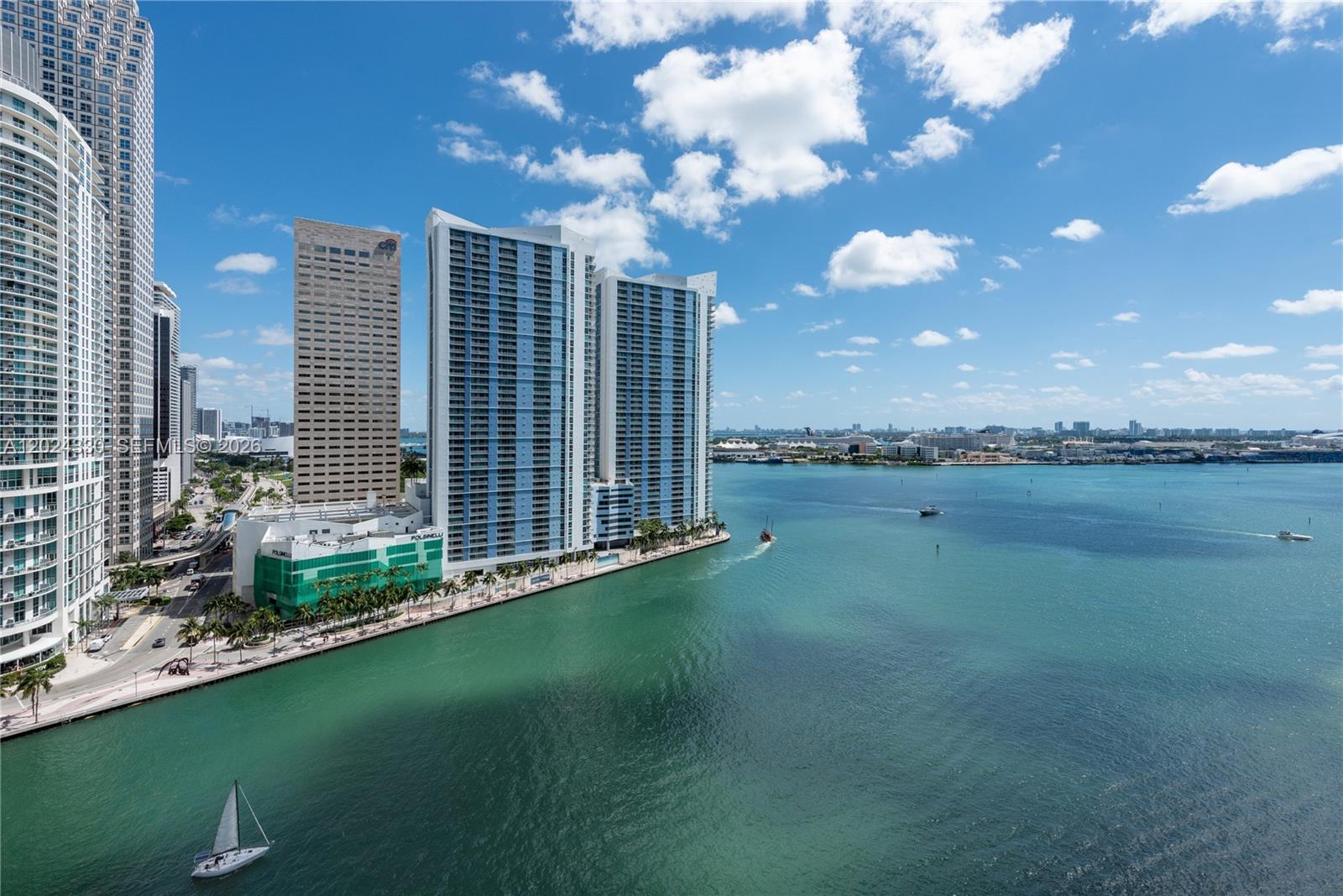 A balcony with tile flooring overlooks a canal and high-rise buildings in a city — 901 Brickell Key Blvd # 2006, Miami FL 33131, MIAMI, FL