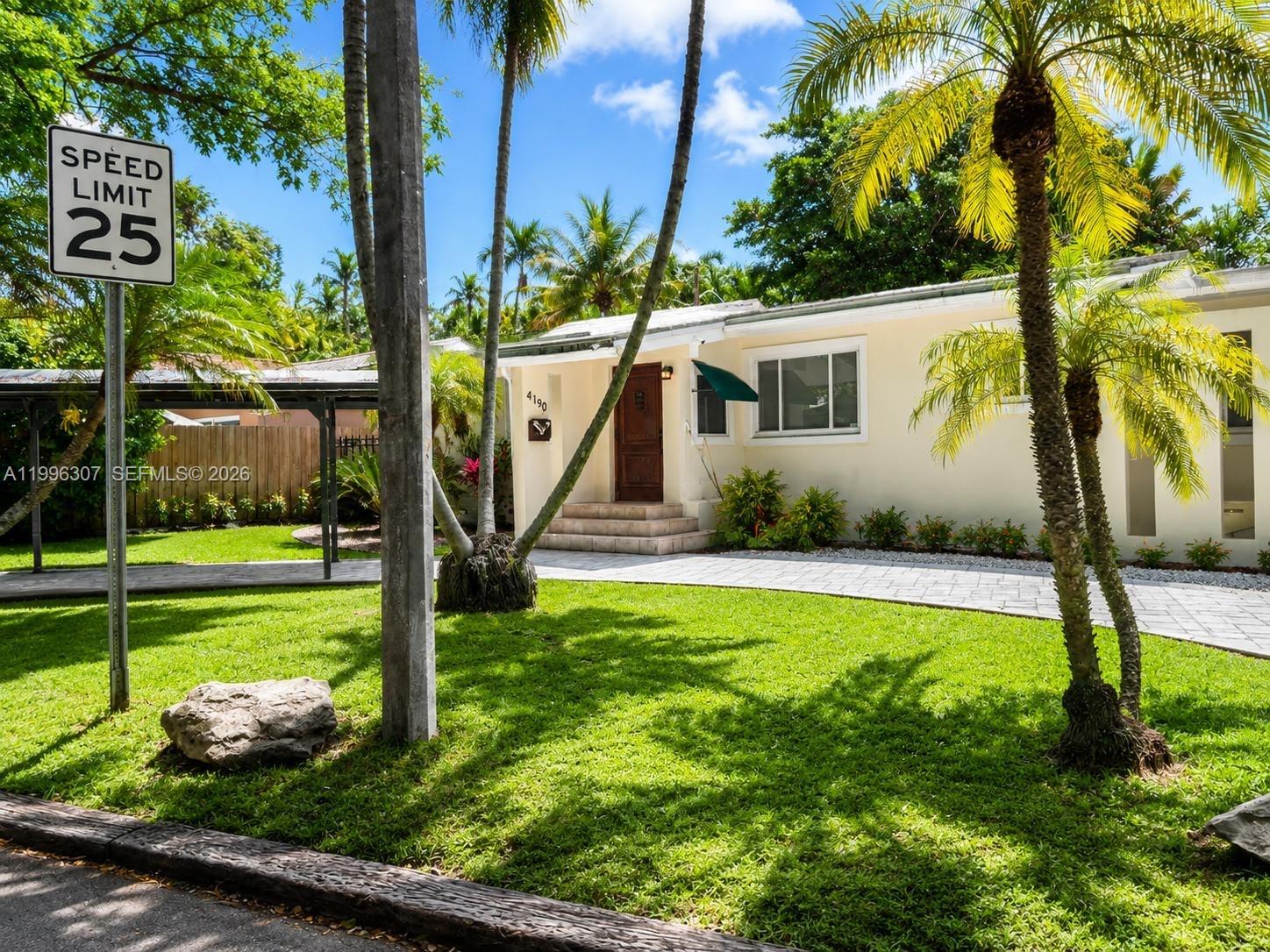 A single-story house with a paved driveway, palm trees, and a speed limit sign — 4190 Pamona Ave # 0, Miami FL 33133, MIAMI, FL