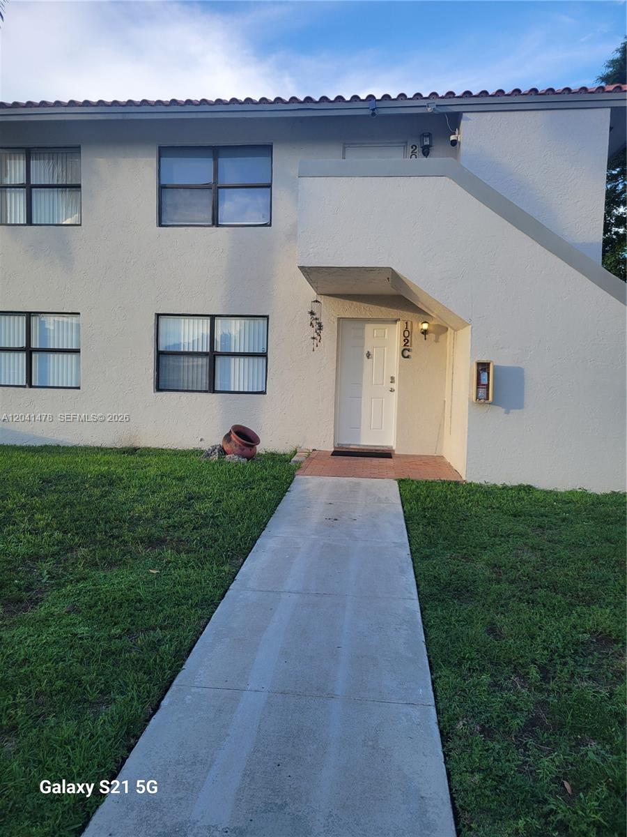 A two-story residential building exterior features a white stucco facade, a front door, and windows — 14831 SW 80th St # 4, Miami FL 33193, MIAMI, FL