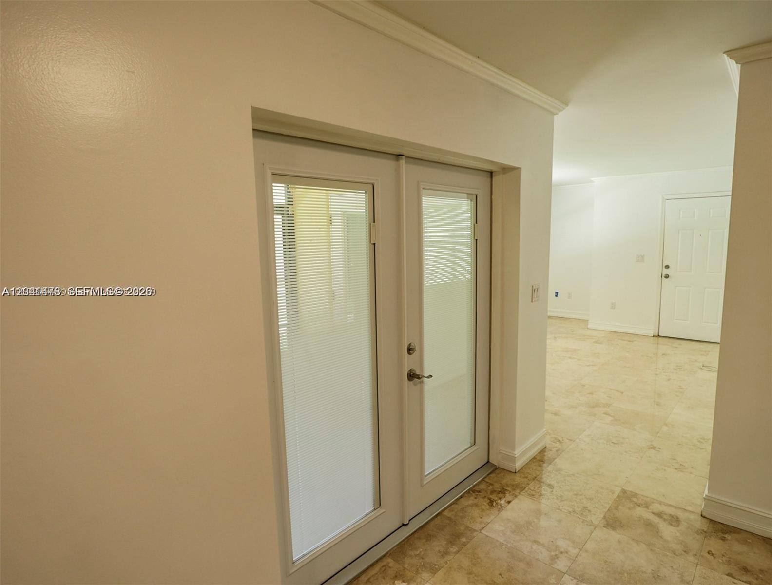 A room features light-colored tile flooring, white walls, and a set of glass-paned double doors — 14831 SW 80th St # 4, Miami FL 33193, MIAMI, FL