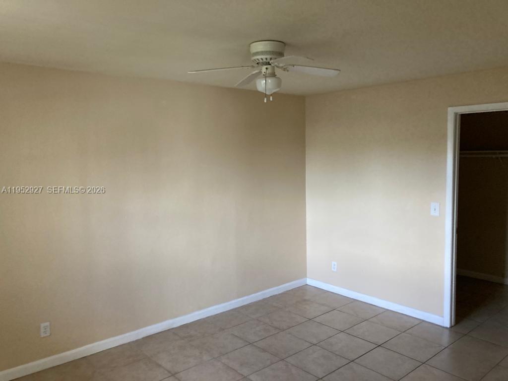 An empty room features beige walls, a ceiling fan, and light-colored tile flooring — 8705 NW 39th St # 0, Sunrise FL 33351, SUNRISE, FL