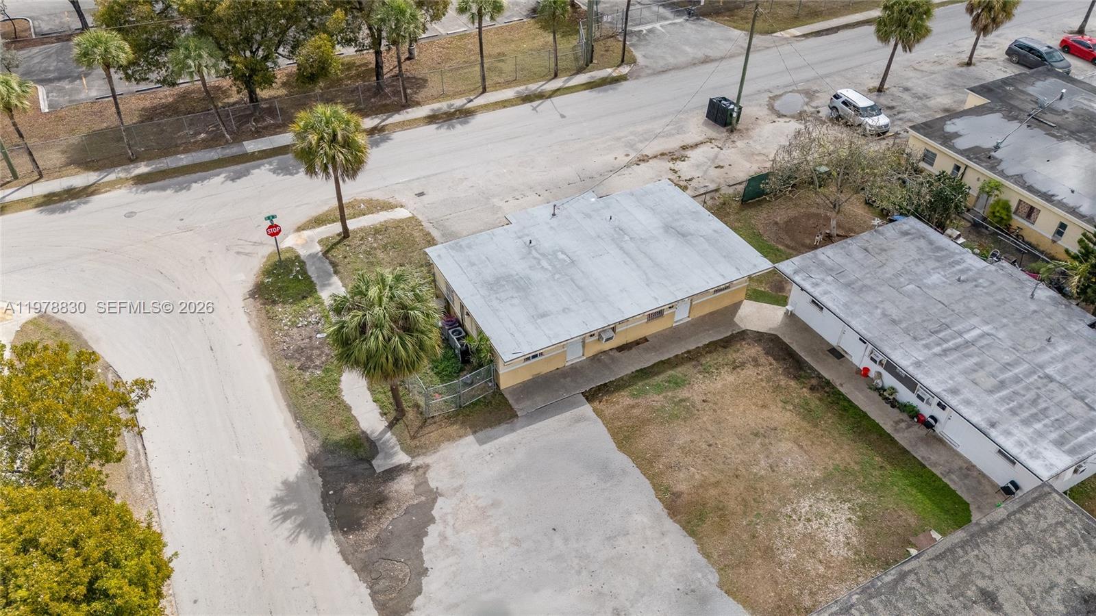 An aerial view shows two adjacent single-story buildings with flat roofs and a paved driveway — 1101 SW 2nd St, Homestead FL 33030, HOMESTEAD, FL