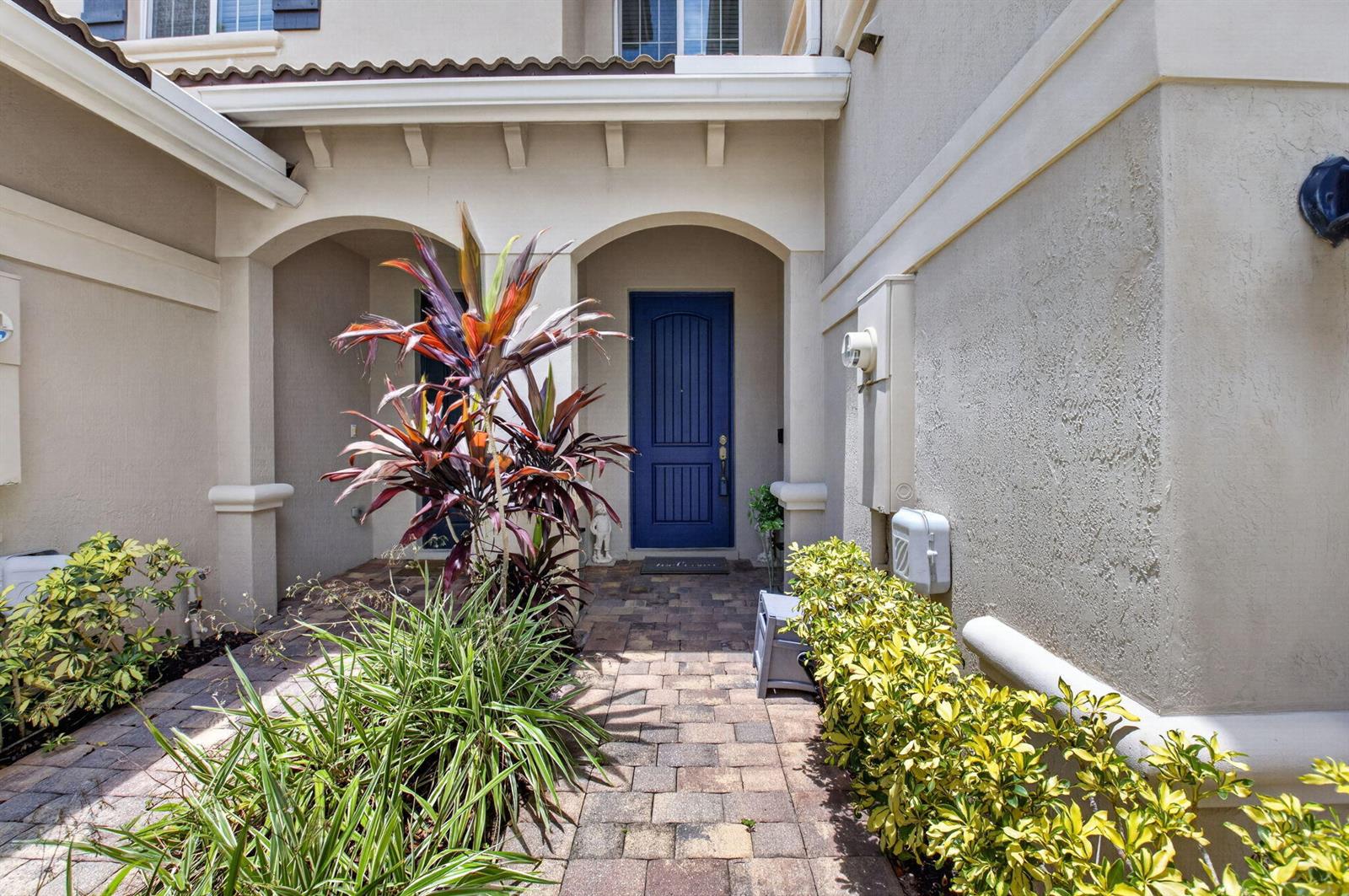 A paved walkway leads to a blue front door under a covered entryway — 2626 Webb Avenue, Delray Beach FL 33444, DELRAY BEACH, FL