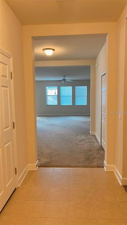 A tiled entryway leads into a carpeted living area with three windows and a ceiling fan — 2931 SHETLAND RIDGE DRIVE, VALRICO, FL