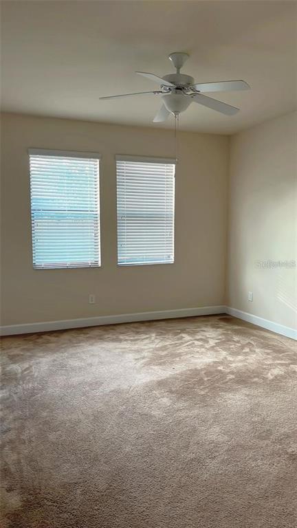 An empty bedroom features beige carpet, two windows with blinds, and a ceiling fan — 2931 SHETLAND RIDGE DRIVE, VALRICO, FL