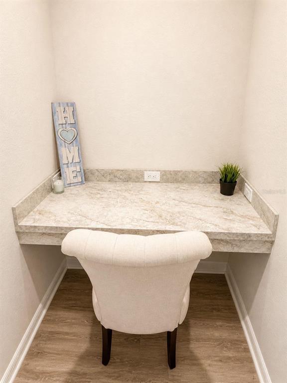 A small built-in desk with a stone countertop and a white upholstered chair — 1032 SILAS STREET, HAINES CITY, FL
