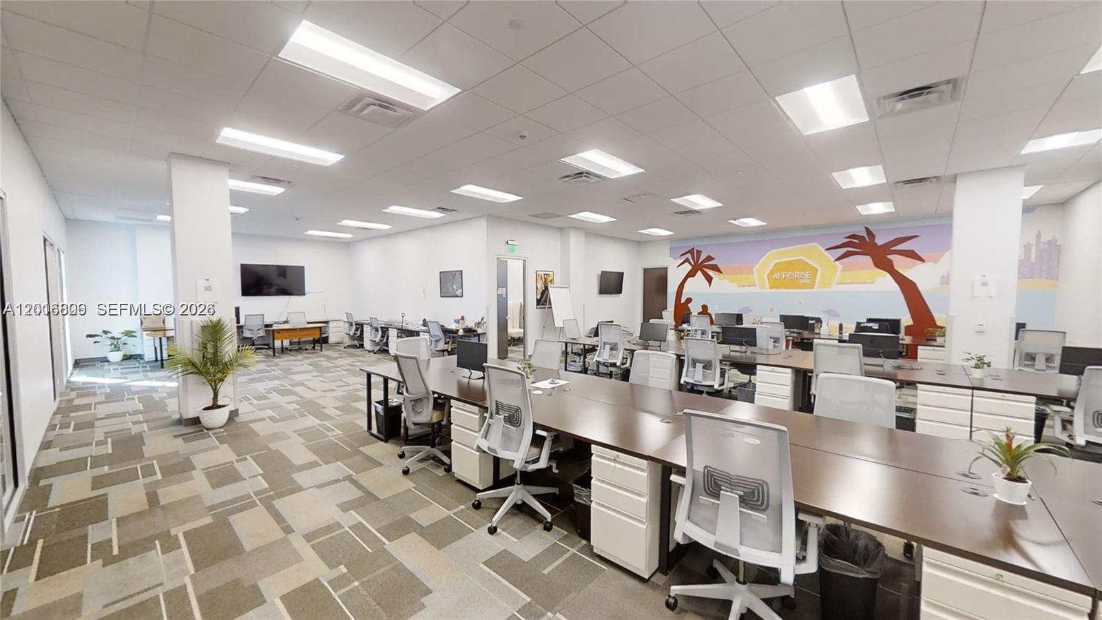 An open-plan office features rows of desks, rolling chairs, and a mural on the back wall — 1501 Biscayne # 501, Miami FL 33132, MIAMI, FL