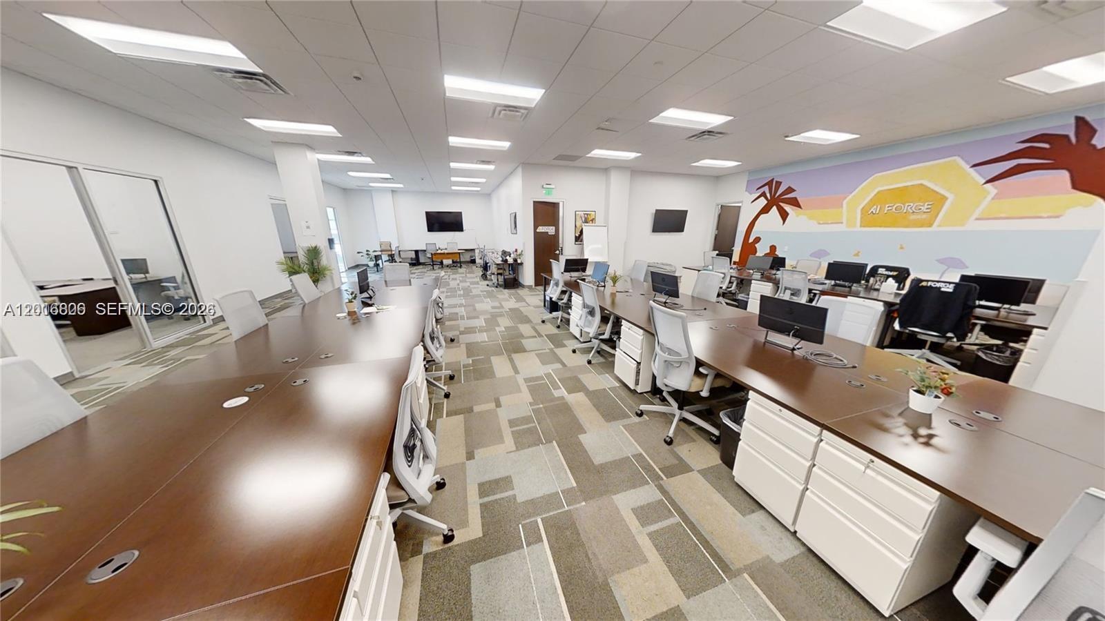 An office space features rows of desks, rolling chairs, and a mural on the wall — 1501 Biscayne # 501, Miami FL 33132, MIAMI, FL