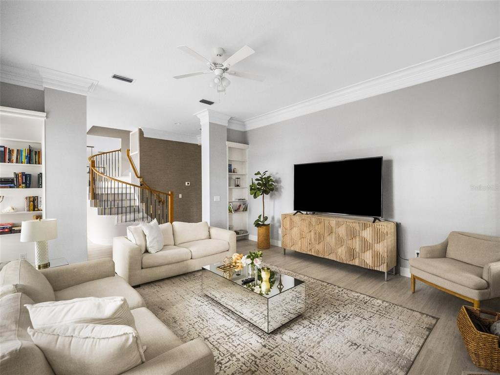 A living room features a mirrored coffee table, two sofas, an armchair, and a television — 10550 LAKE MINNEOLA SHORES, CLERMONT, FL