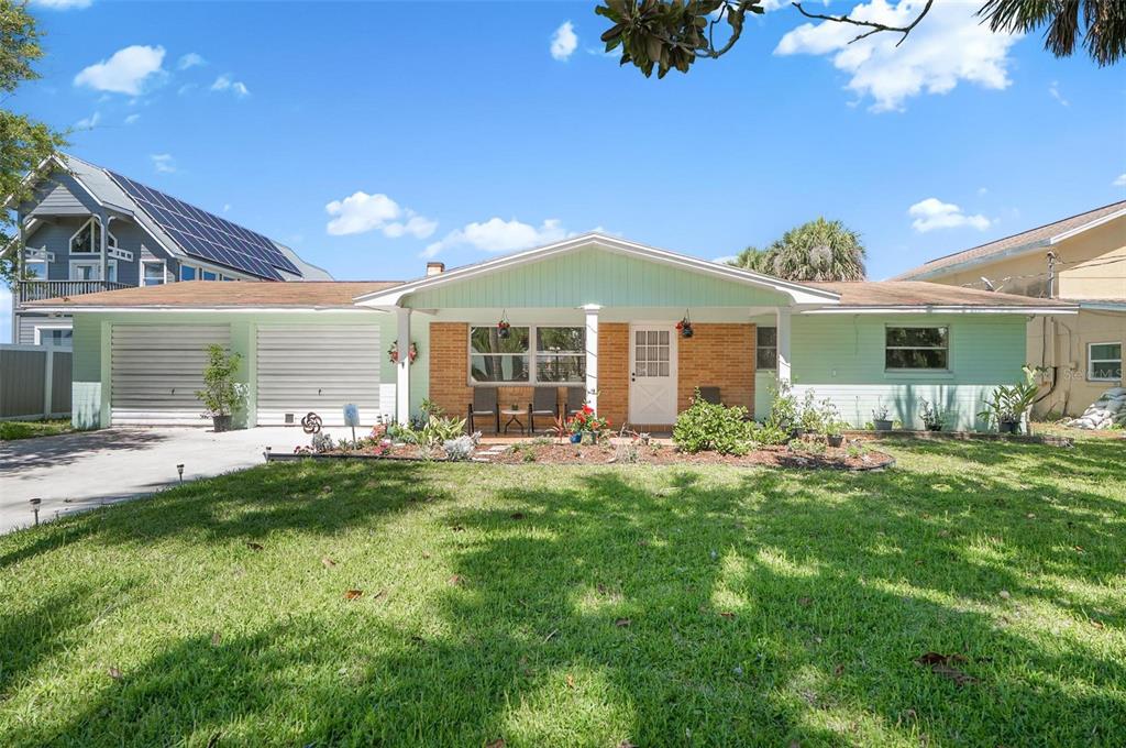 A single-story house with a light green exterior, brick accents, and a two-car garage — 420 LAMBERT AVENUE, FLAGLER BEACH, FL