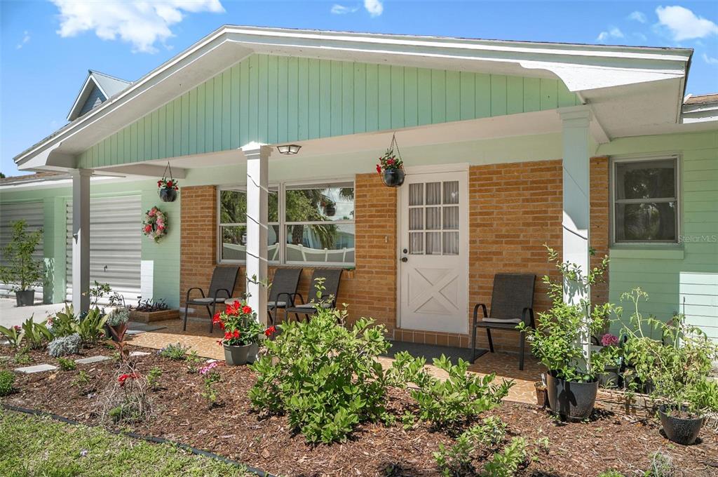 A light green house exterior features a brick facade, a covered porch, and landscaping — 420 LAMBERT AVENUE, FLAGLER BEACH, FL