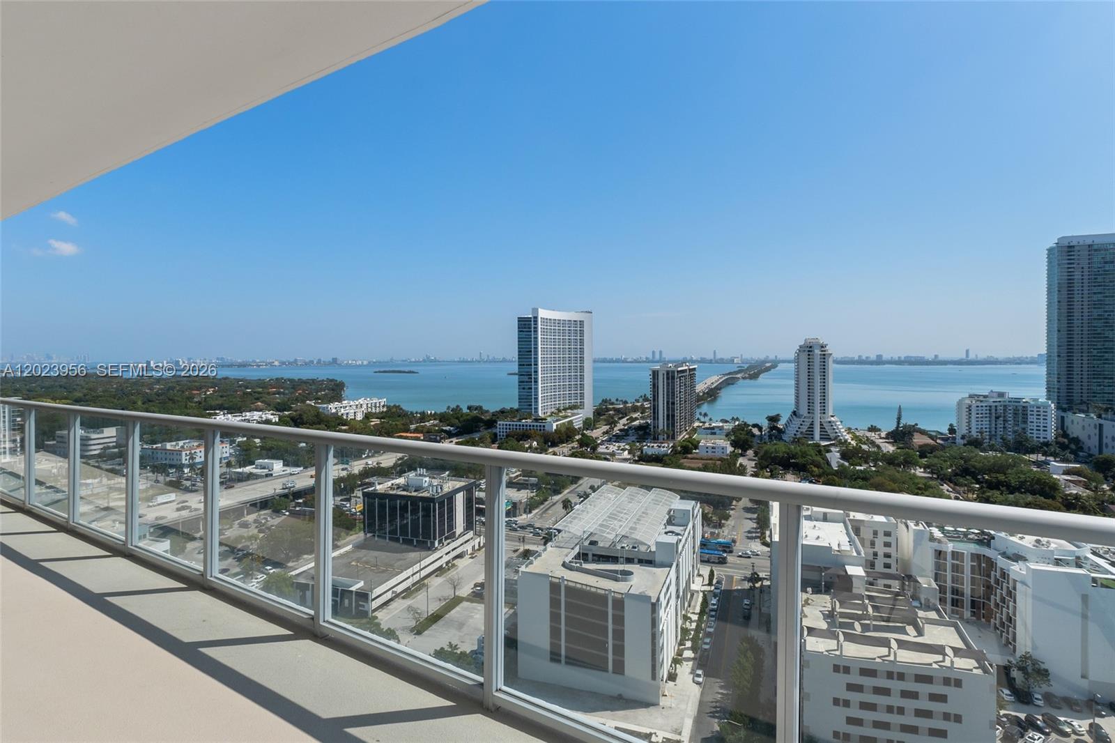 A high-rise balcony overlooks a city skyline, a bridge, and a large body of water — 3470 E Coast Ave # H2309, Miami FL 33137, MIAMI, FL