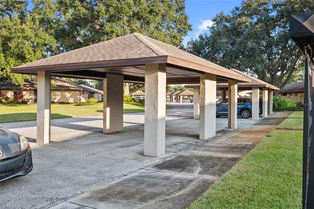 A covered carport structure with concrete pillars stands over a paved parking area — 2270 FIRESTONE PLACE, WINTER HAVEN, FL