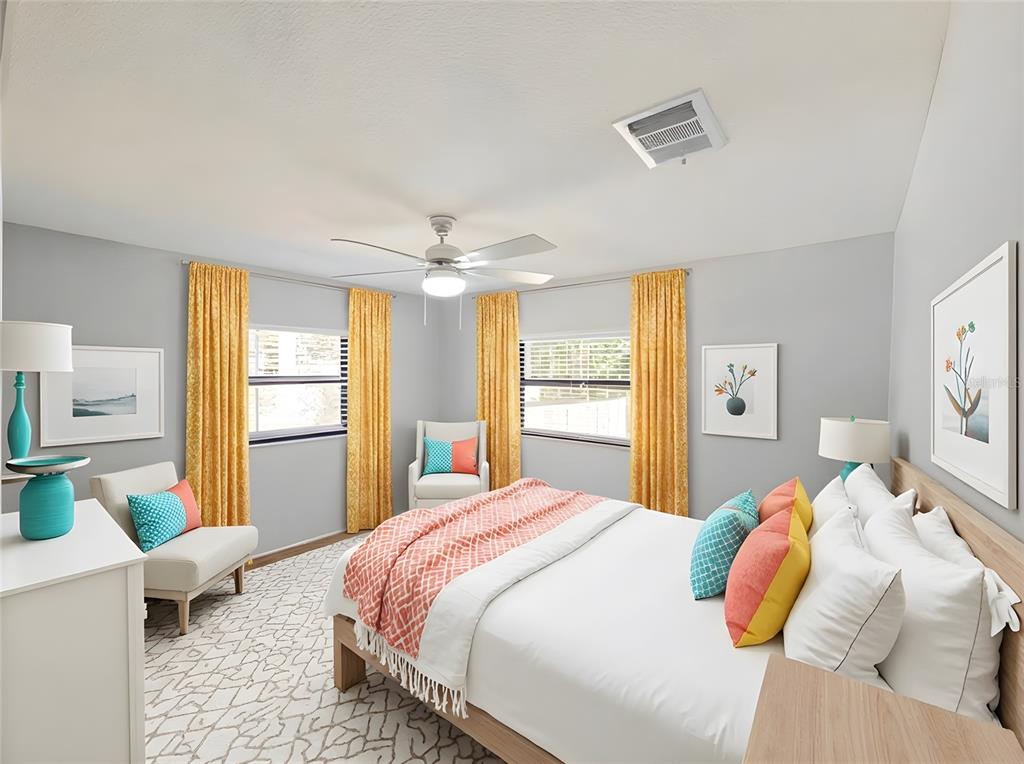 A bedroom features a bed with coral and yellow pillows, yellow curtains, and gray walls — 2941A SHORE DRIVE, SAFETY HARBOR, FL